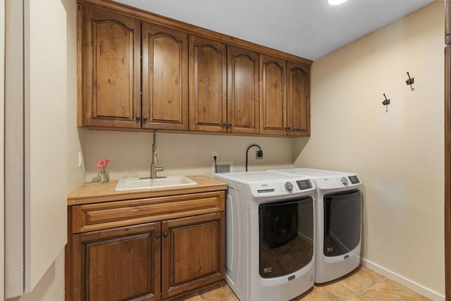 washroom with cabinets, sink, washing machine and dryer, and light tile patterned flooring