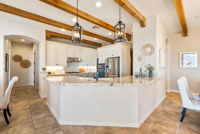 kitchen featuring kitchen peninsula, white cabinetry, light stone countertops, stainless steel appliances, and a chandelier