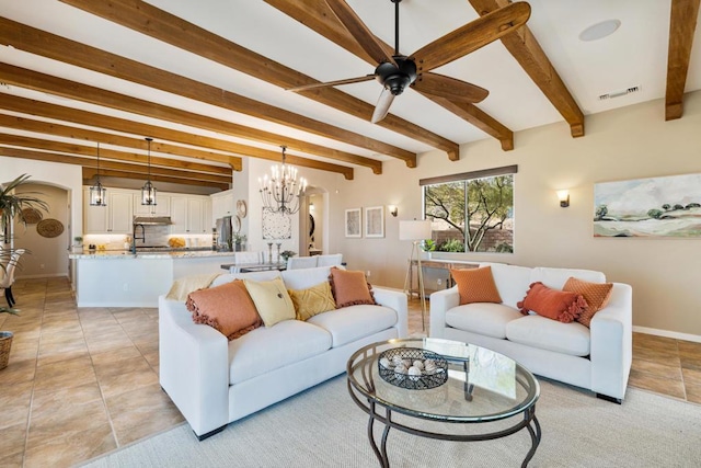 living room with ceiling fan with notable chandelier, sink, and beamed ceiling