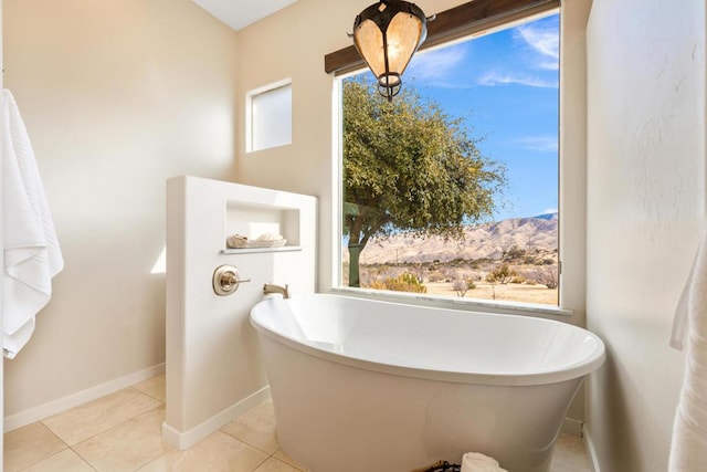 bathroom featuring a mountain view, a bath, and tile patterned flooring