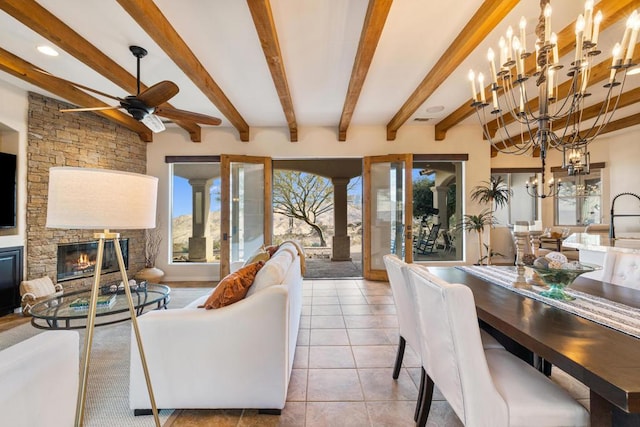 tiled living room with ceiling fan with notable chandelier, a fireplace, and beamed ceiling