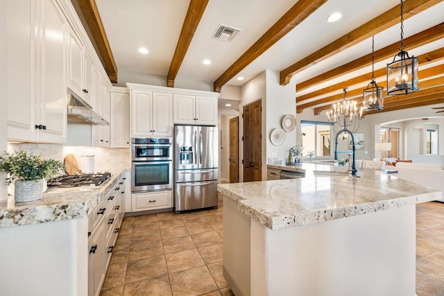 kitchen featuring pendant lighting, appliances with stainless steel finishes, white cabinetry, decorative backsplash, and sink