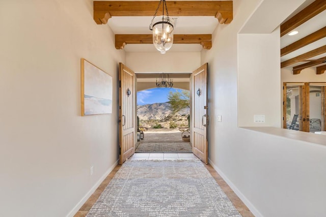 doorway to outside featuring light tile patterned floors, beam ceiling, and a chandelier