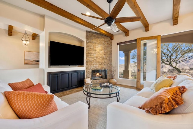 living room with a fireplace, beam ceiling, and ceiling fan