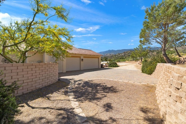 exterior space with a garage and a mountain view