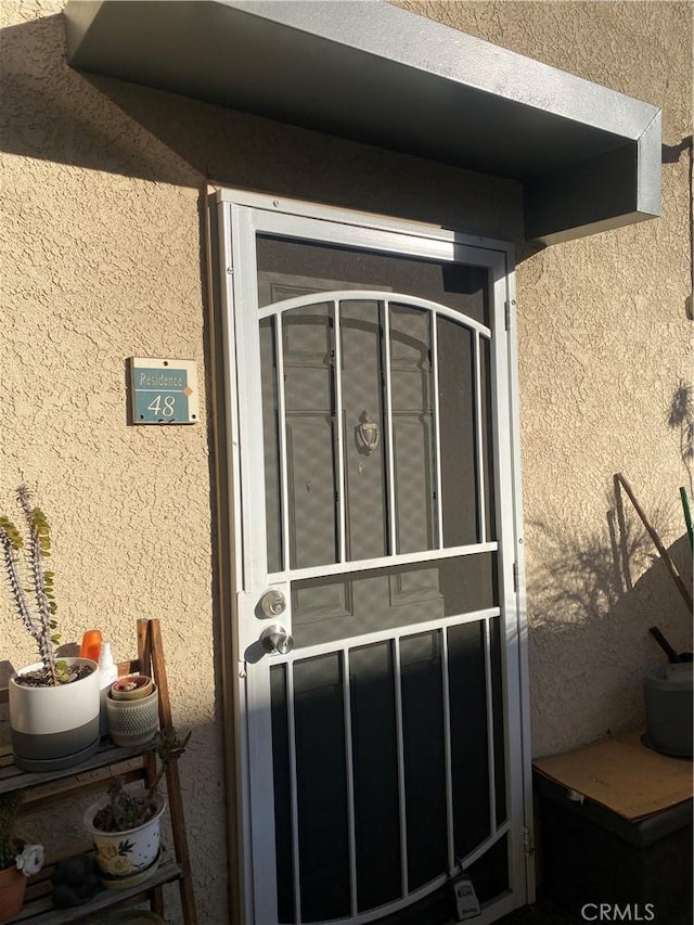 view of exterior entry with stucco siding