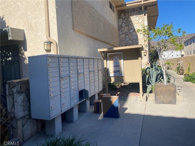 view of home's community with fence and mail area