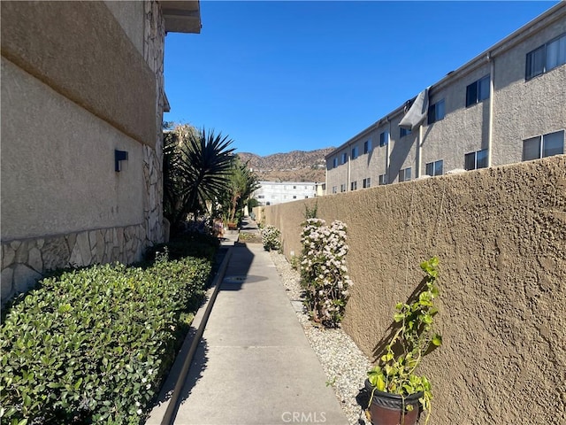 exterior space with a residential view, fence, a mountain view, and stucco siding