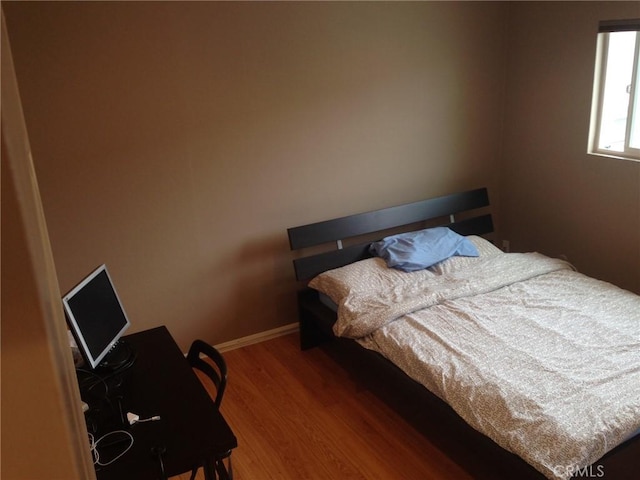 bedroom featuring baseboards and wood finished floors