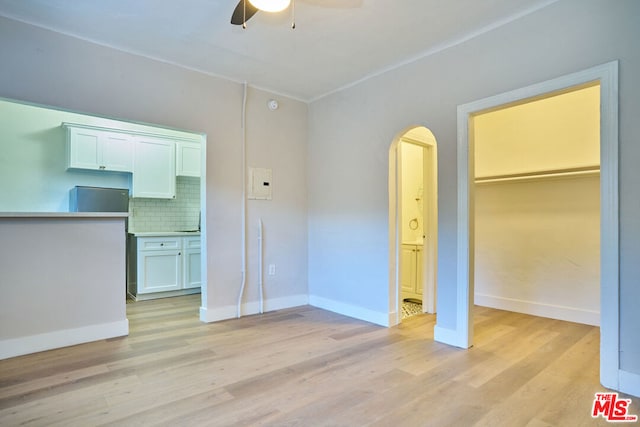 interior space featuring ceiling fan, ensuite bath, a closet, and light hardwood / wood-style floors