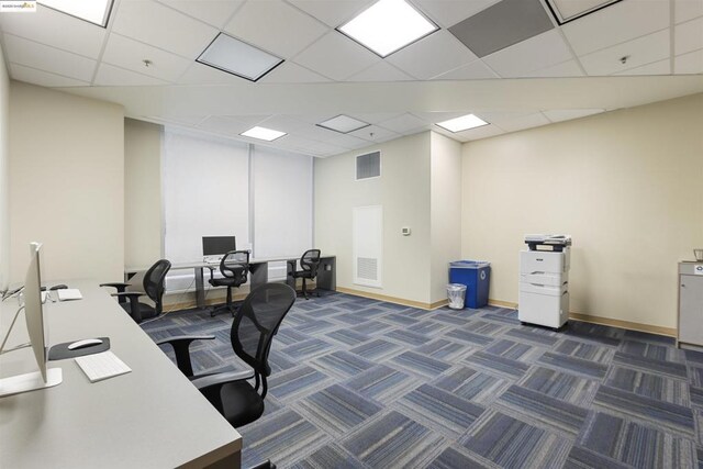 carpeted office space featuring a paneled ceiling