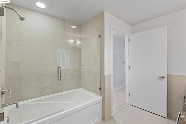 bathroom featuring tile walls, combined bath / shower with glass door, and tile patterned flooring