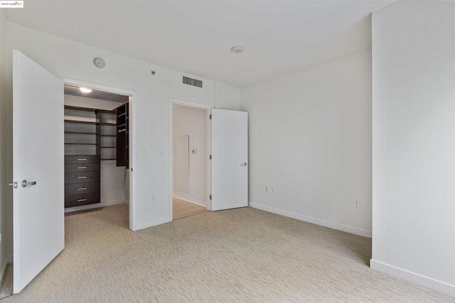 unfurnished bedroom featuring a closet and a spacious closet