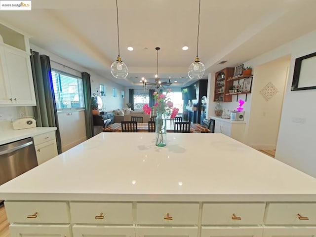 kitchen featuring decorative light fixtures, dishwasher, a center island, and light hardwood / wood-style flooring