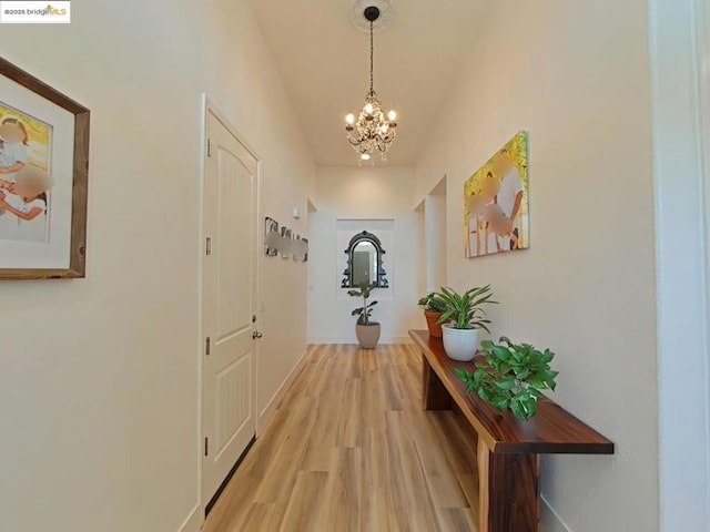 hall featuring a chandelier and light wood-type flooring