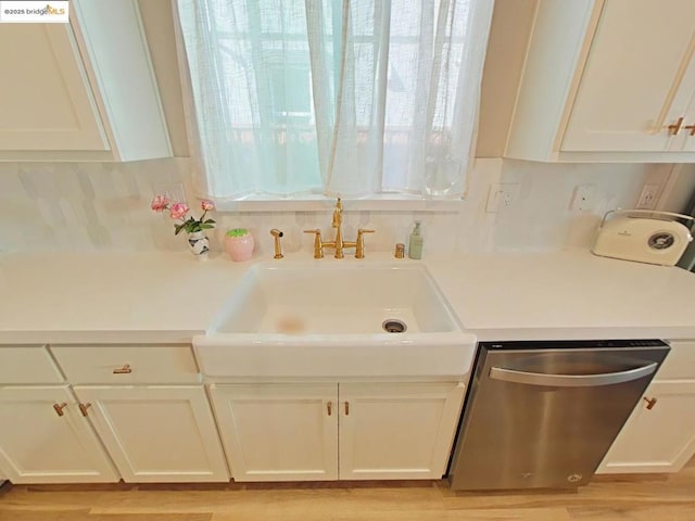 kitchen with decorative backsplash, sink, white cabinetry, and stainless steel dishwasher