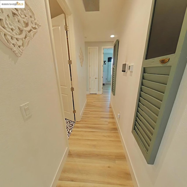 corridor with light hardwood / wood-style flooring