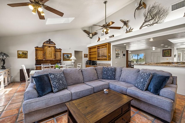 living room with light tile patterned floors, a skylight, ceiling fan, and high vaulted ceiling