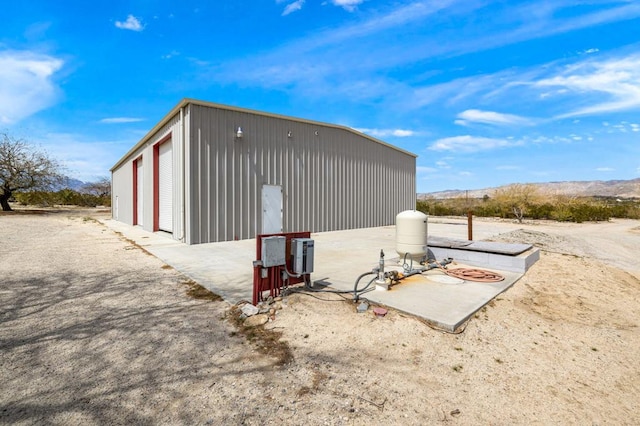 view of side of property with a garage, an outbuilding, and a mountain view