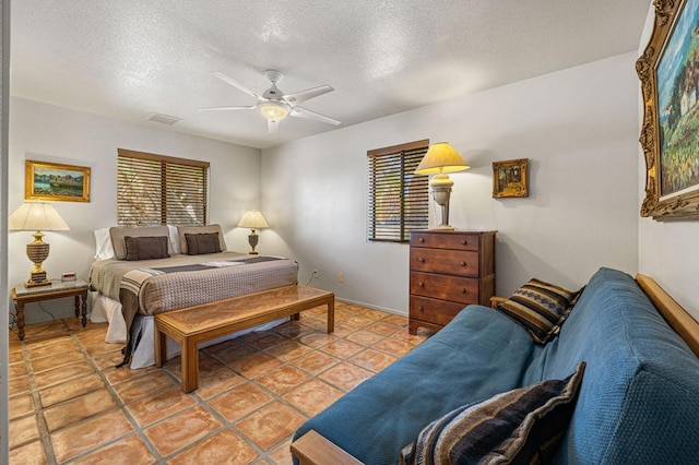 tiled bedroom featuring a textured ceiling and ceiling fan