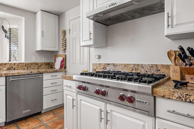 kitchen with exhaust hood, stainless steel appliances, dark stone countertops, and white cabinets