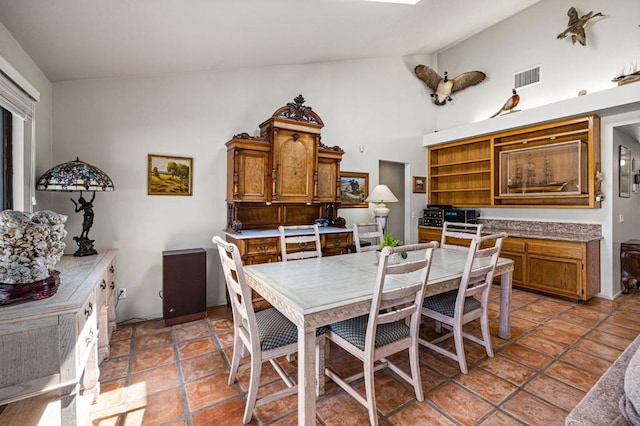 dining space with lofted ceiling and light tile patterned flooring