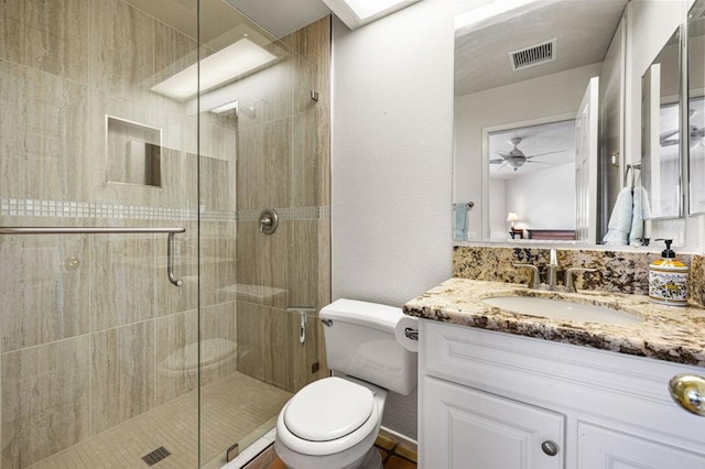 bathroom with toilet, ceiling fan, an enclosed shower, and vanity