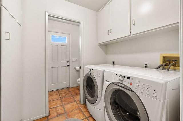 clothes washing area with cabinets and washing machine and dryer