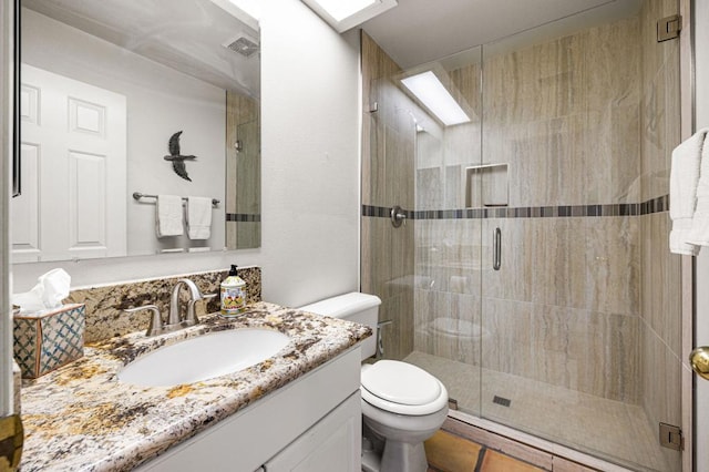 bathroom featuring toilet, tile patterned flooring, an enclosed shower, and vanity