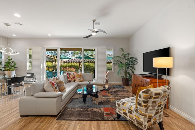 living room featuring ceiling fan and light hardwood / wood-style flooring