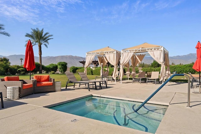 view of pool with a mountain view and a patio