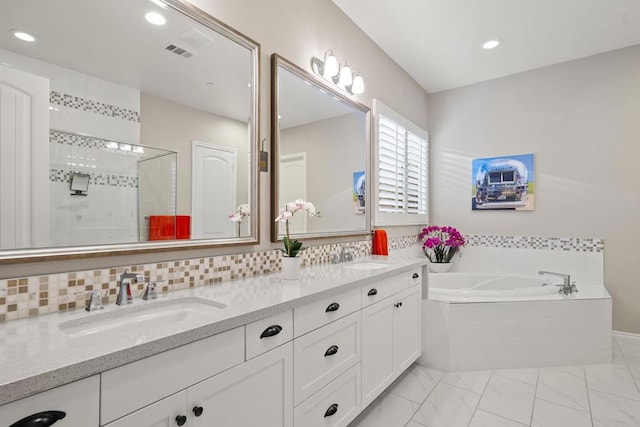 bathroom featuring shower with separate bathtub and vanity