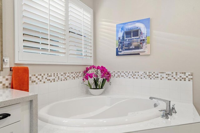 bathroom with tiled bath and vanity