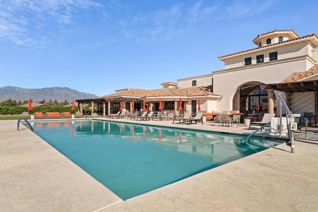 view of pool featuring a mountain view and a patio area