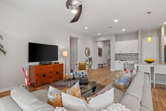 living room featuring ceiling fan and light hardwood / wood-style flooring