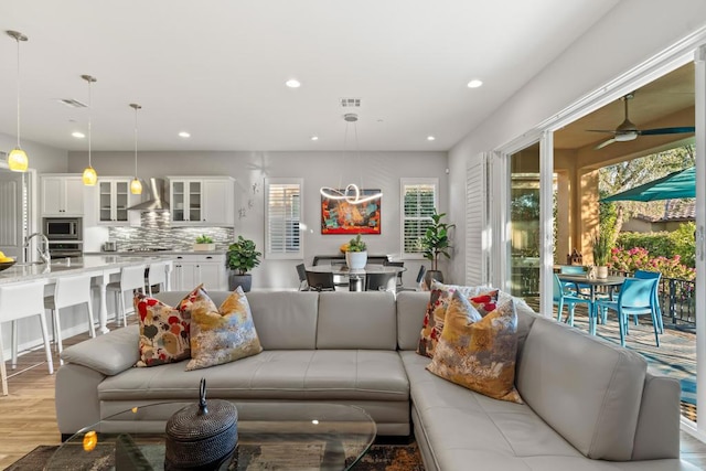 living room featuring ceiling fan and light hardwood / wood-style floors