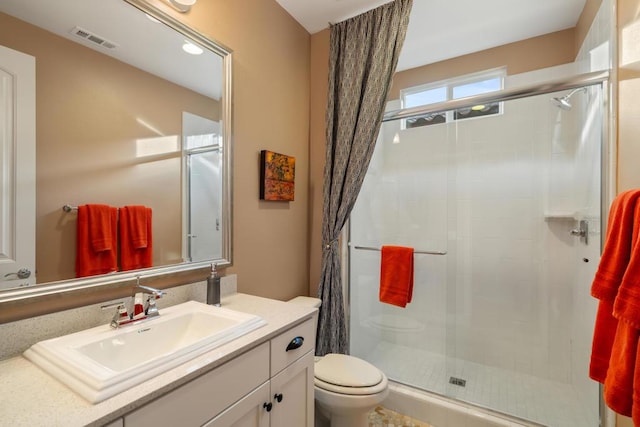 bathroom featuring toilet, walk in shower, and vanity