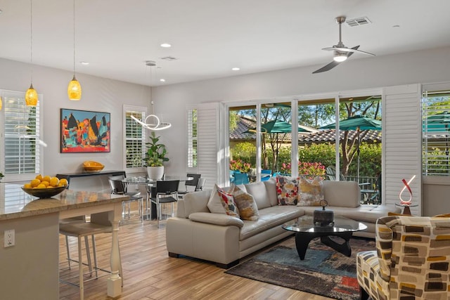 living room featuring light hardwood / wood-style floors, a wealth of natural light, and ceiling fan