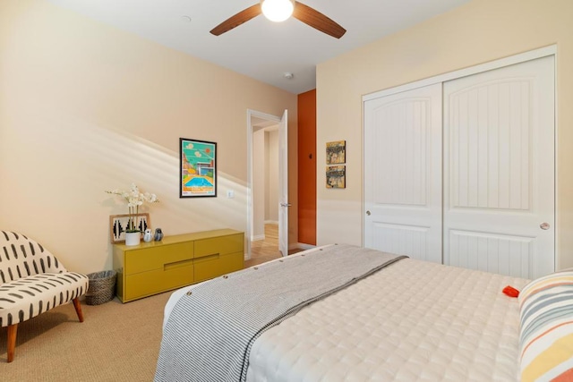 bedroom with ceiling fan, a closet, and light carpet