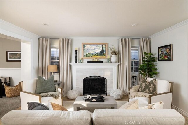 carpeted living room with crown molding and a tile fireplace