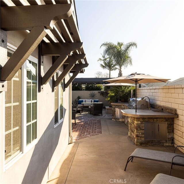 view of patio / terrace featuring an outdoor hangout area, a grill, and an outdoor kitchen