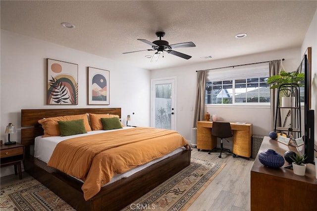 bedroom featuring ceiling fan, a textured ceiling, and light hardwood / wood-style flooring