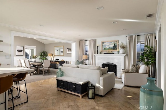 living room with vaulted ceiling, a wealth of natural light, and ornamental molding