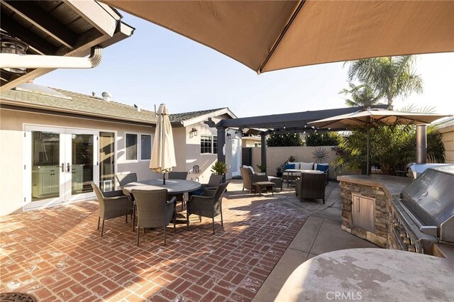 view of patio with an outdoor hangout area, grilling area, french doors, and exterior kitchen