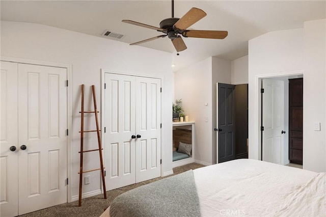 bedroom with ceiling fan, carpet, and multiple closets