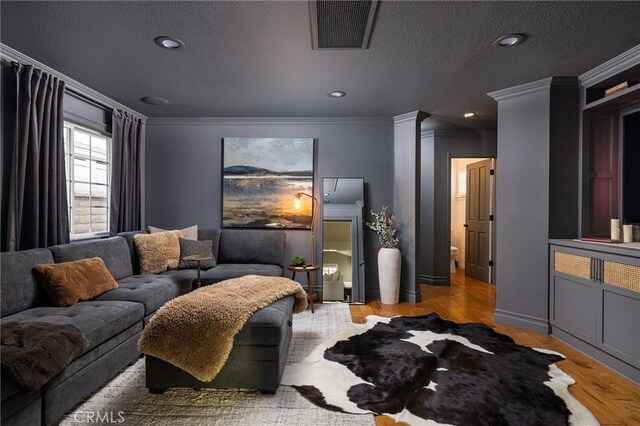 living room with crown molding and light hardwood / wood-style flooring