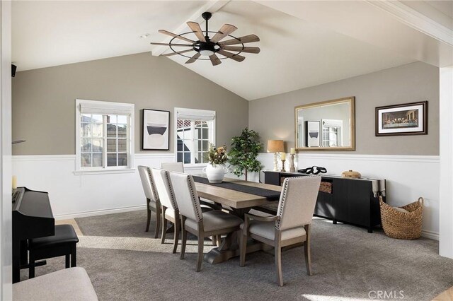 carpeted dining space featuring ceiling fan and vaulted ceiling with beams