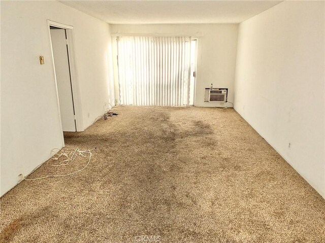 carpeted empty room featuring a wall mounted AC