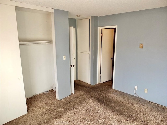 unfurnished bedroom featuring a closet and dark colored carpet