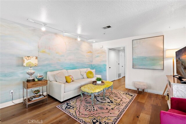 living room with wood-type flooring and a textured ceiling